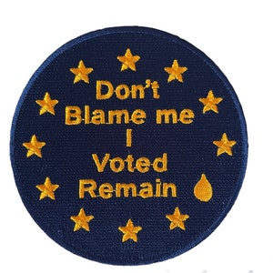 May include: A blue circular patch with a circle of gold stars around the edge. The text "Don't Blame me I Voted Remain" is written in gold lettering with a gold teardrop below the text.