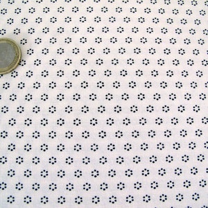 Könnte beinhalten: Weißer Stoff mit einem sich wiederholenden Muster aus kleinen schwarzen Kreisen, die in einer kreisförmigen Form angeordnet sind.