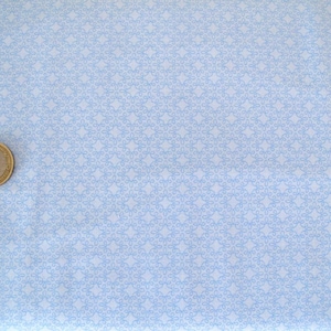 Op de afbeelding: Een lichtblauwe stof met een wit, herhalend patroon van kleine, ingewikkelde ontwerpen.