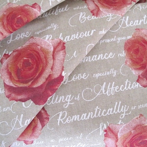 May include: Beige fabric with a repeating pattern of red roses and white cursive text. The text includes phrases like "Love", "Romance", "Affection", and "Beautiful".