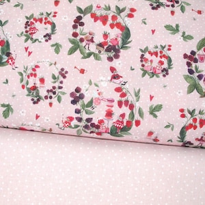 Può includere: Tessuto rosa con un motivo ripetuto di ghirlande di fragole e more, piccole figure e pois bianchi. Il tessuto è piegato, rivelando un tessuto rosa tinta unita con pois bianchi.