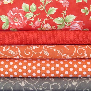 Könnte beinhalten: Fünf Stoffmuster, die übereinander gestapelt sind. Das oberste Muster ist rot mit einem Blumenmuster. Das zweite Muster ist rot mit einem gewebten Muster. Das dritte Muster ist orange mit einem Blumenmuster. Das vierte Muster ist orange mit weißen Punkten. Das unterste Muster ist grau mit einem Blumenmuster.