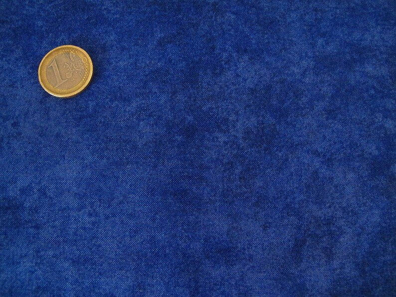 K&ouml;nnte beinhalten: Eine einzelne Euro-M&uuml;nze auf einem blauen, strukturierten Hintergrund.