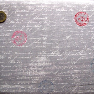 Könnte beinhalten: Grauer Stoff mit einem weißen Schriftmuster und mehreren roten und blauen Gummistempeln. Die Stempel haben den Text "BOUTIQUE" und "SOUVENIR".