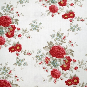 Può includere: Tessuto bianco con motivo floreale ripetuto. Grandi rose rosse e fiori rossi e blu più piccoli sono sparsi sul tessuto. Le foglie sono di colore verde e marrone tenue. Una moneta è nell'immagine per la scala.
