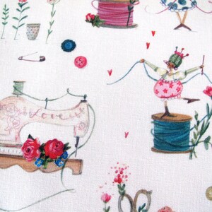 May include: A white fabric with a repeating pattern of sewing-themed illustrations. The design includes a vintage sewing machine with the word "Love", spools of thread, buttons, flowers, and a whimsical figure. Red hearts and pink roses add color.