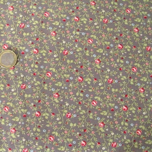 Op de afbeelding: Een grijze stof met een klein bloemenpatroon. Het patroon heeft kleine rode, roze en blauwe bloemen met groene bladeren.