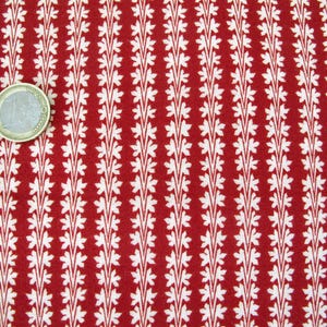 Peut inclure: Tissu rouge avec un motif blanc répétitif de petites feuilles en lignes verticales.