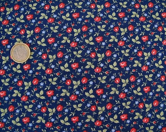 Könnte beinhalten: Ein marineblauer Stoff mit einem sich wiederholenden Muster aus kleinen roten und blauen Blumen. Der Stoff ist mit einem dichten Blumenmuster bedeckt.