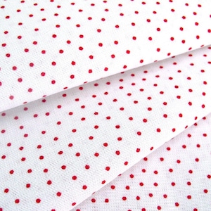 May include: White fabric with a red polka dot pattern. The fabric is folded in thirds, showing the pattern from different angles.