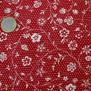 Könnte beinhalten: Roter Stoff mit einem weißen Blumenmuster. Der Stoff hat ein kleines weißes Punkte-Muster.