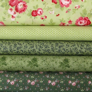 Könnte beinhalten: Ein Stapel Stoffrollen in verschiedenen Grüntönen. Die oberste Schicht zeigt einen hellgrünen Stoff mit großen roten und rosa Rosen. Weitere Schichten umfassen Stoffe mit kleinen Mustern, Blattdesigns und Blumendrucken. Ideal für Patchwork- und Nähprojekte.