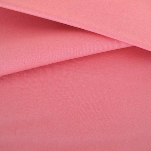 Könnte beinhalten: Nahaufnahme eines glatten, rosafarbenen Stoffes, der in zwei Hälften gefaltet ist. Der Stoff hat einen dezenten Glanz und eine weiche Textur.