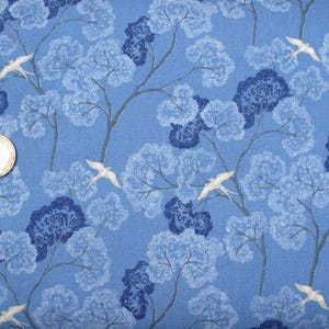 Könnte beinhalten: Blauer Stoff mit einem weißen Silhouettenmuster von Bäumen und Vögeln. Der Stoff hat eine subtile Textur.
