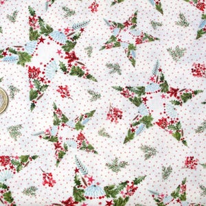 May include: White fabric featuring a repeating pattern of Christmas stars. Each star is made up of green leaves, red berries, and blue accents. Small red dots are scattered across the white background, creating a festive holiday design.