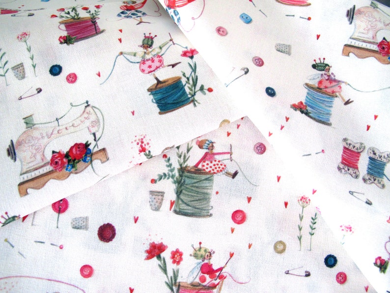 May include: White fabric with a whimsical sewing-themed print. The design features illustrations of sewing machines, spools of thread, buttons, and fairies. Red hearts and flowers add pops of color to the design.