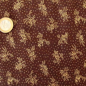 May include: Brown fabric with a repeating pattern of small gold flowers and white dots.