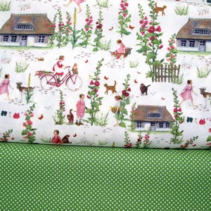 May include: White fabric with a repeating pattern of houses, flowers, children, animals, and bicycles. The fabric is folded in half, revealing a green fabric with white polka dots underneath.