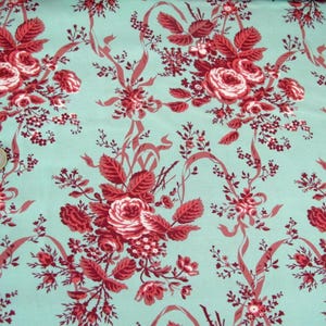Könnte beinhalten: Tealfarbener Stoff mit einem sich wiederholenden Muster aus roten Rosen und grünen Blättern. Die Rosen sind in Büscheln angeordnet und haben eine weiße Mitte. Der Stoff hat einen Vintage-Look.