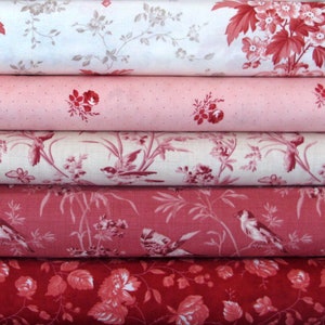 Könnte beinhalten: Fünf Rollen Stoff mit einem floralen Muster in Rosa- und Rottönen. Der Stoff hat einen Vintage-Look und ist perfekt zum Quilten, Nähen oder Basteln.