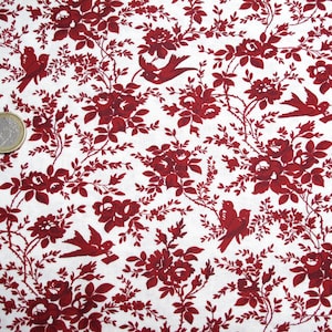 Könnte beinhalten: Roter Blumenstoff mit einem sich wiederholenden Muster aus kleinen roten Rosen, Blättern und Vögeln auf weißem Hintergrund.