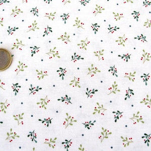 Könnte beinhalten: Weißer Stoff mit einem sich wiederholenden Muster aus kleinen grünen Zweigen mit roten Beeren und winzigen blauen Punkten.