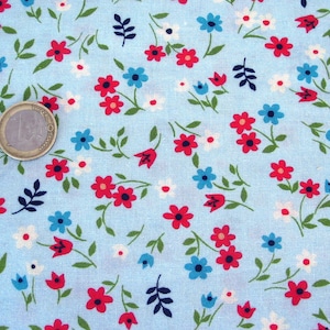 Könnte beinhalten: Ein hellblauer Stoff mit einem sich wiederholenden Muster aus kleinen roten, blauen und weißen Blumen. Der Stoff hat eine subtile Textur.