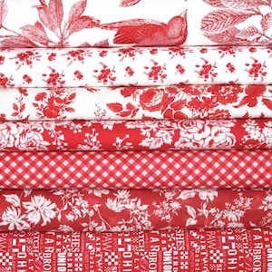 Könnte beinhalten: Ein Stapel aus sieben gefalteten Stoffballen mit verschiedenen rot-weißen Mustern, darunter ein Vogel- und Pflanzenmotiv, florale Designs, ein klassisches Vichy-Karo und eine untere Lage mit wiederholtem Text und grafischen Symbolen in Rot.