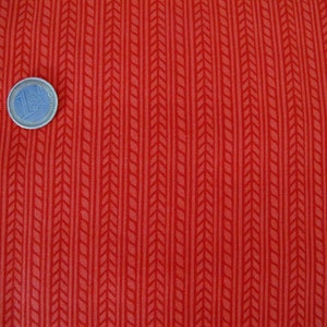 Könnte beinhalten: Roter Stoff mit einem weißen Chevron-Muster. Der Stoff hat einen dezenten Glanz und eine glatte Textur.