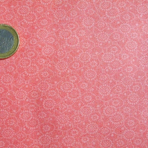 May include: A close-up of a red fabric with a white pattern. The fabric has a subtle texture and a slightly faded appearance.
