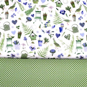 Könnte beinhalten: Weißer Stoff mit einem Gartenmuster mit Vögeln, Farnen, Gießkannen, Vogelhäusern und Blumen in Grün und Blau. Darunter grüner Stoff mit weißen Punkten.