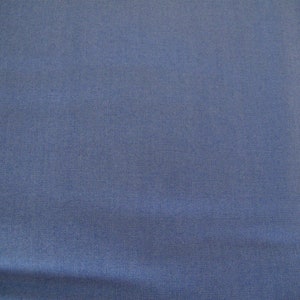 Könnte beinhalten: Nahaufnahme eines einfarbigen, blauen Stoffes mit einer dezenten, gewebten Struktur. Der Stoff hat eine leichte Falte in der Mitte.