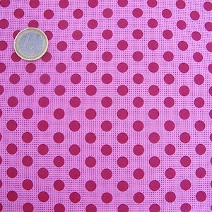 Peut inclure: Tissu rose avec un motif répétitif de pois rouge foncé.
