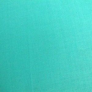 Può includere: Un tessuto color turchese solido con una sottile trama tessuta.