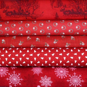 May include: A stack of red Christmas-themed fabric rolls. The patterns include a winter scene with a horse-drawn carriage, circles with white accents, small white flowers, white Christmas trees, and large snowflakes.