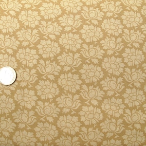 Può includere: Un tessuto beige con un motivo floreale bianco. Il tessuto ha una leggera lucentezza e una texture morbida.