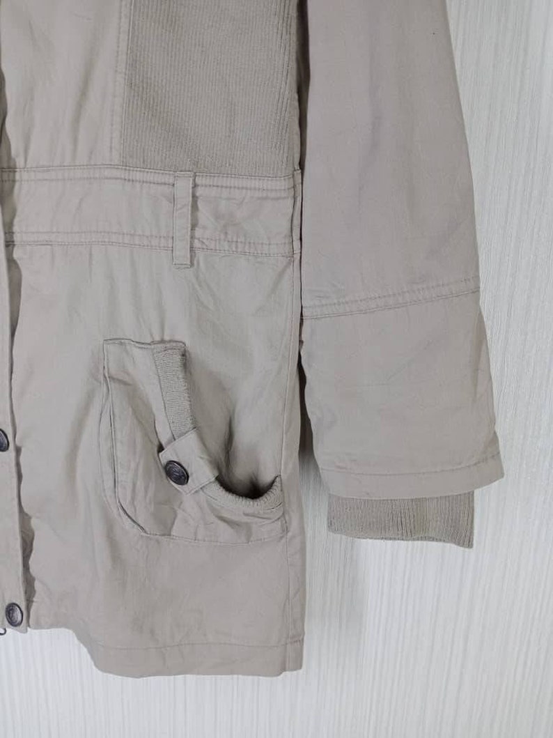 Peut inclure: Une veste beige avec un panneau en velours c&ocirc;tel&eacute; sur le devant et une fermeture &agrave; boutons. La veste a une poche sur le c&ocirc;t&eacute; gauche et une manchette c&ocirc;tel&eacute;e sur la manche droite.