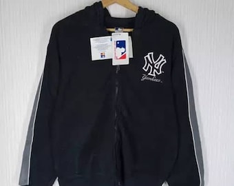 May include: Black zip-up hoodie with white and gray trim. The hoodie features a large white New York Yankees logo with the word "Yankees" underneath.