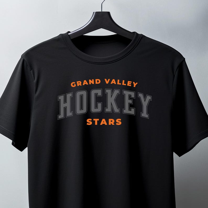 May include: Black t-shirt with the text "GRAND VALLEY HOCKEY STARS" in orange and gray lettering.