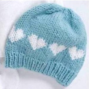 Puede incluir: Un gorro de punto azul claro con diseños de nubes blancas. El gorro está hecho de hilo suave y tiene un ajuste cómodo.