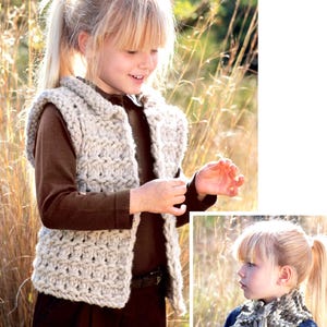 May include: A light beige, chunky knit vest with a collar. The vest is worn over a brown long-sleeved shirt and a dark brown skirt. The image is of a young person in a field of tall grass.