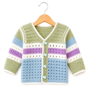 May include: A long-sleeve crochet cardigan featuring a V-neckline and four light blue buttons. The garment displays horizontal stripes in sage green, white, lavender, and light blue, with a textured stitch pattern throughout the body and sleeves.