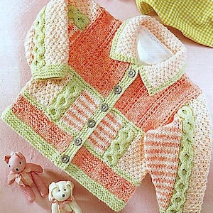May include: A knitted baby cardigan with a button fastening, featuring a colourful striped and cable knit pattern in shades of peach, green, and white.