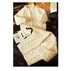 Puede incluir: Un cárdigan de punto crema para bebé y pantalones a juego con un patrón de punto de cable. El cárdigan tiene cierre de botón en el cuello y mangas raglán. Tallas 45-60 cm.