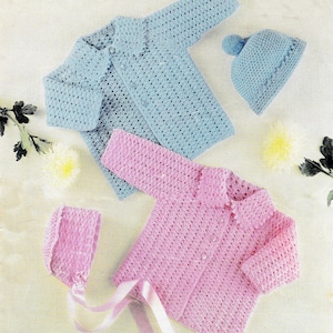 Könnte beinhalten: Zwei gehäkelte Babyjacken und Mützen. Eine Jacke ist hellblau mit einer passenden Mütze, die andere ist rosa mit einer passenden Mütze. Die rosa Mütze hat ein Band darum gebunden.