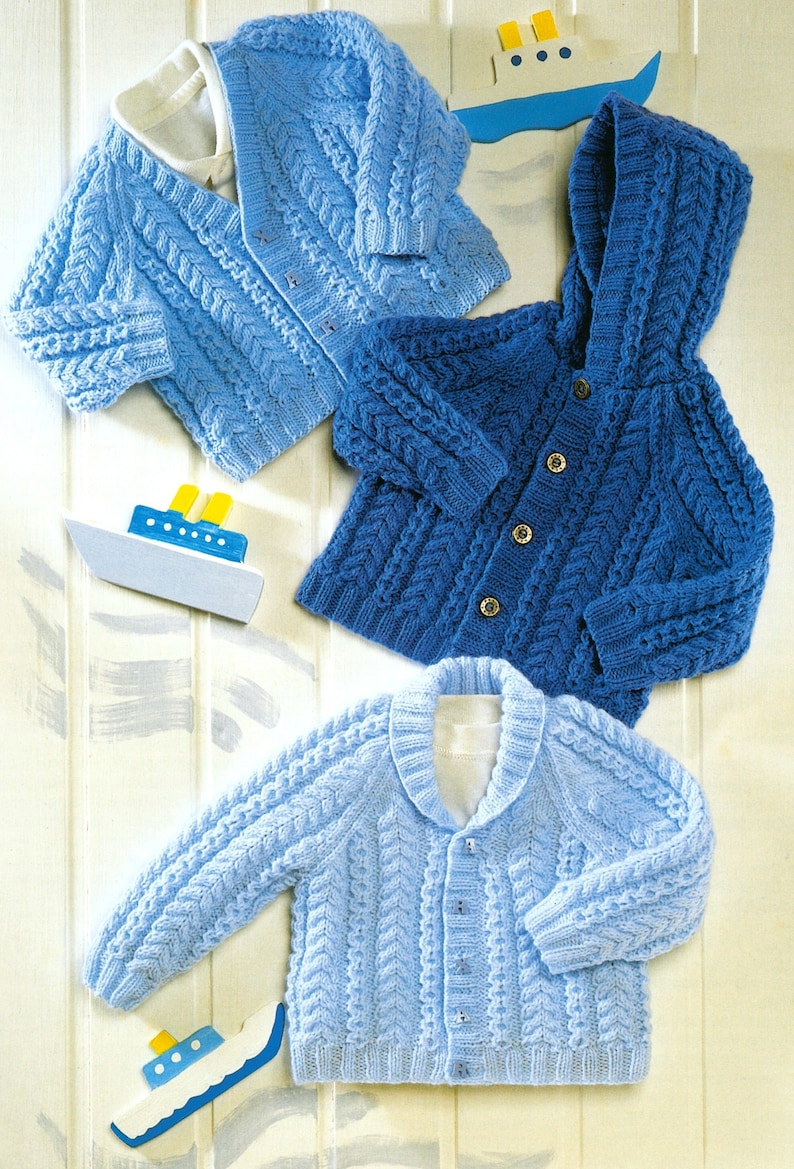 May include: Three knitted baby sweaters in blue shades. One sweater has a hood, one has a collar, and one has a simple neckline. All sweaters feature a cable knit pattern.