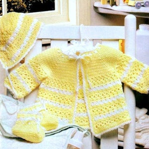 May include: A crocheted baby outfit in yellow and white. The set includes a hat, cardigan, and booties.