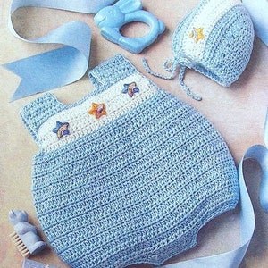 May include: A crocheted baby outfit in light blue with white accents and star-shaped embellishments. The outfit includes a matching hat with a white brim and star embellishments.