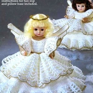 May include: Two crocheted angel dolls dressed in white gowns with gold trim. The dolls are wearing halos and have long, flowing hair. The dolls are suitable for a 13 inch music box doll or a 10 1/2 inch pillow doll.