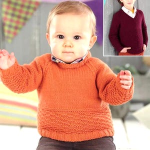 May include: An orange knitted sweater with a textured pattern at the bottom and on the sleeves. The sweater has a high collar and is worn by a baby. A smaller image shows a burgundy V-neck sweater.
